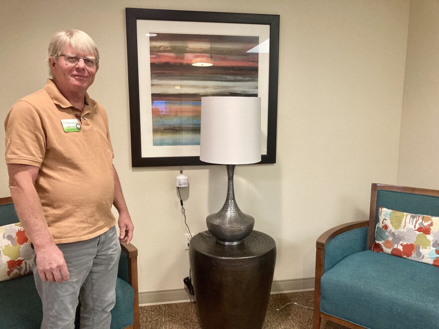 Mark Troen stands in front of the indoor air quality monitor