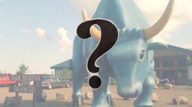 A large blue ox looms in a parking lot near a sign reading "Paul Bunyan, Brainerd"; a question mark in the foreground