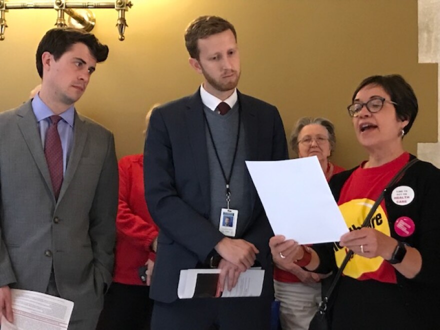 Rob Blanchard, deputy director of communications for Gov. Ned Lamont, left, and Jonny Dach, Lamont's policy director, listen as Frances G. Padilla, president of the Universal Health Care Foundation of Connecticut, speaks during Health Care Action Day.