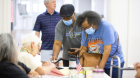 A voter presents identification to a precinct official at The Village Bible Church in The Village on June 16, 2026.