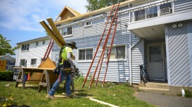 A construction worker carries lumber for the roof of a building being renovated in the Colonial Village public housing complex in Norwalk. After spending years to get local zoning approval, the project is now waiting on state funding to move forward. Every year, state legislators earmark millions of dollars to build new affordable housing. But as the housing market has heated up, Connecticut Public’s Accountability Project has found there’s a $450 million pot of money that hasn’t been spent.