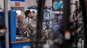 Students work on bike wheels in a classroom.