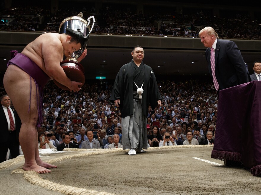 President Trump presents the President's Cup to the Tokyo Grand Sumo Tournament winner Asanoyama on Sunday.