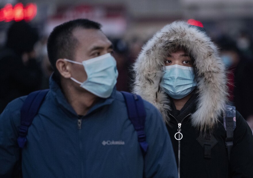 Chinese travelers at a railway station in Beijing, China, wear face masks to protect themselves from the new coronavirus on Jan. 21, 2020. The virus was first identified in Wuhan, China, in Dec. 2019, and since then has quickly spread worldwide.