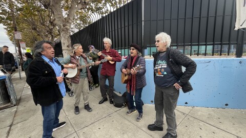 A group of musicians performs at a gathering on the corner of Market and Brockhurst in Oakland.