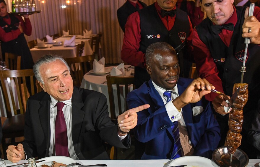 Brazil's President Michel Temer, left, held a dinner at a <em>churrascaria</em> in Brasilia to reassure ambassadors, such as Angola's Nelson Manuel Cosme, that the meat their countries are buying is of high quality.