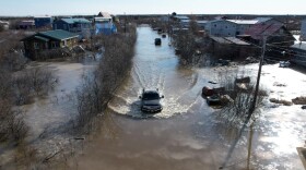 a truck drives through floodwaters
