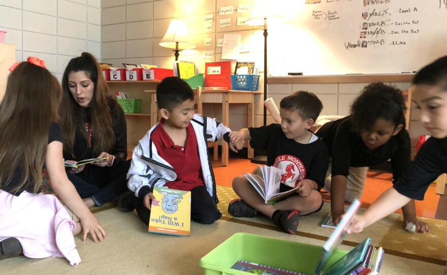 A teacher sits and reads with her students at Steele Montessori Academy in southeast San Antonio in March 2018.