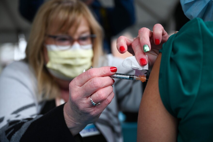 December 14, 2020: Hartford Healthcare nurse Marylou Oshana administers the Pfizer BioNTech COVID-19 vaccine to patient care associate Jasmine Ortiz after the vaccine’s arrival at Hartford Hospital earlier in the morning. 