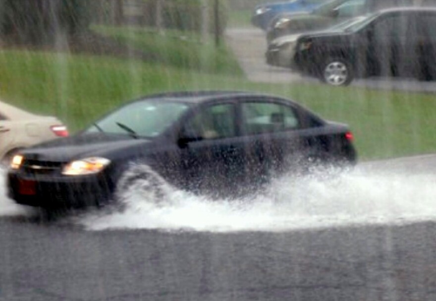 A car runs through high water in south Tulsa.
