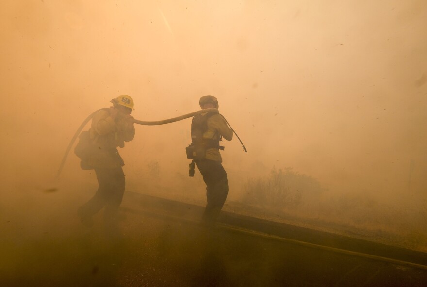 Firefighters battle a fire along the Ronald Reagan Freeway in Simi Valley.