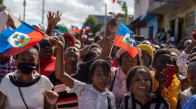 People wave flags and march during a rally organized by Christians to denounce the high levels of crime in Haiti in Port-au-Prince, Haiti.