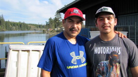 Shane Underwood (left) and his son, David, stand at the Quinault Indian Nation’s seafood plant in Taholah, Washington. The loss of the largest glacier that feeds the Quinault River and rising seas are threatening the tribe’s way of life.