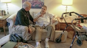 Nurse practitioner Dwayne Dobschuetz, left, visits patient Marvin Shimp, at Shimp's home in Chicago on Jan. 10, 2018. Shimp has lost much of his vision to macular degeneration and Dobschuetz's house calls help him stay out of the hospital with regular visits to check vitals and answer questions. Dobschuetz sees several patients in their homes each day, traveling by bicycle. He works at Northwestern Medicine in Chicago, which is taking a new approach to helping older patients stay healthier. (AP Photo/Teresa Crawford)