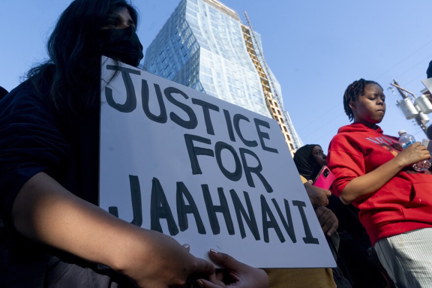 A protester holds a sign that reads, "Justice for Jaahnavi" standing with a group of other protesters.