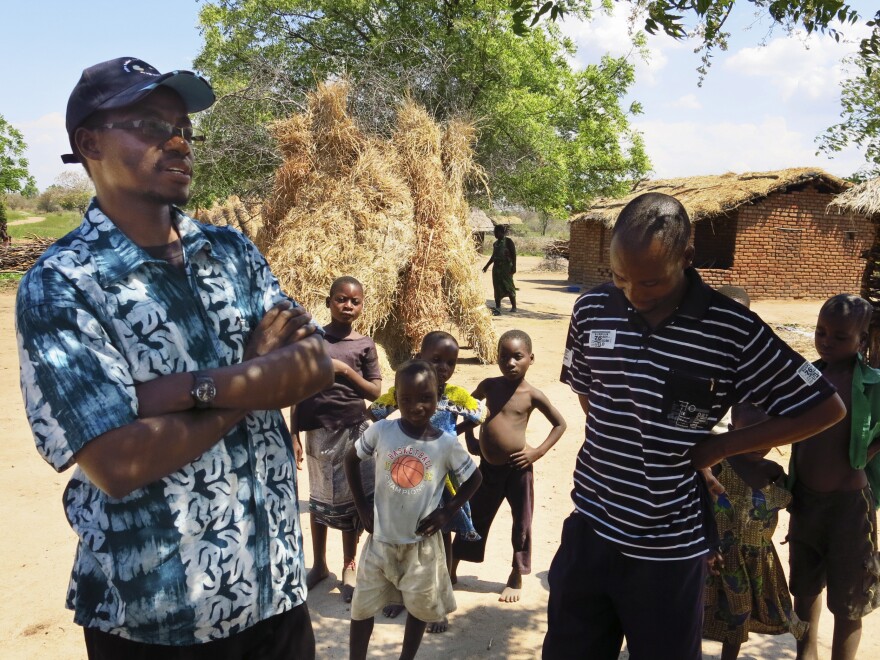 Victor Mughogho (left) is the executive director of Eagles Relief and Development, a nonprofit organization that's helping farmers adapt to climate change. He talks with villagers in Jasi, where his group has also donated goats so that people can sell the offspring if their harvest falls short.