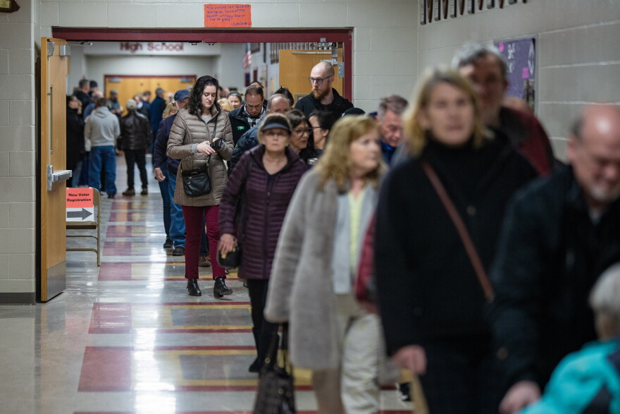 Hundreds of voters line up down a hallway of Bedford High School as the polls open in the morning. (Jesse Costa/WBUR)