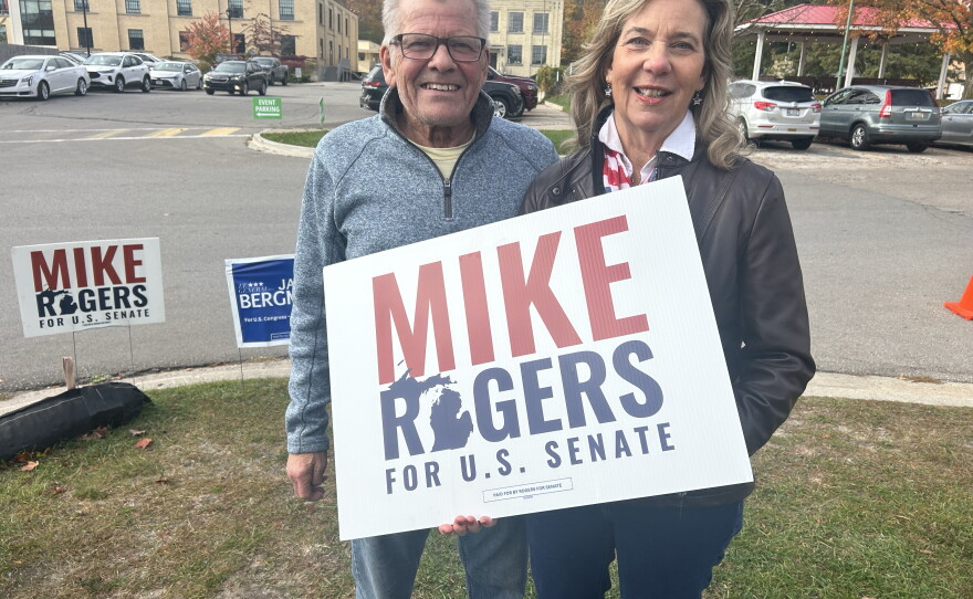 Two Mike Rogers supporters John and Cheryl Sowash outside of a campaign event hosted by the Northern Michigan Chamber Alliance in Traverse City on Friday, Oct. 23, 2026.