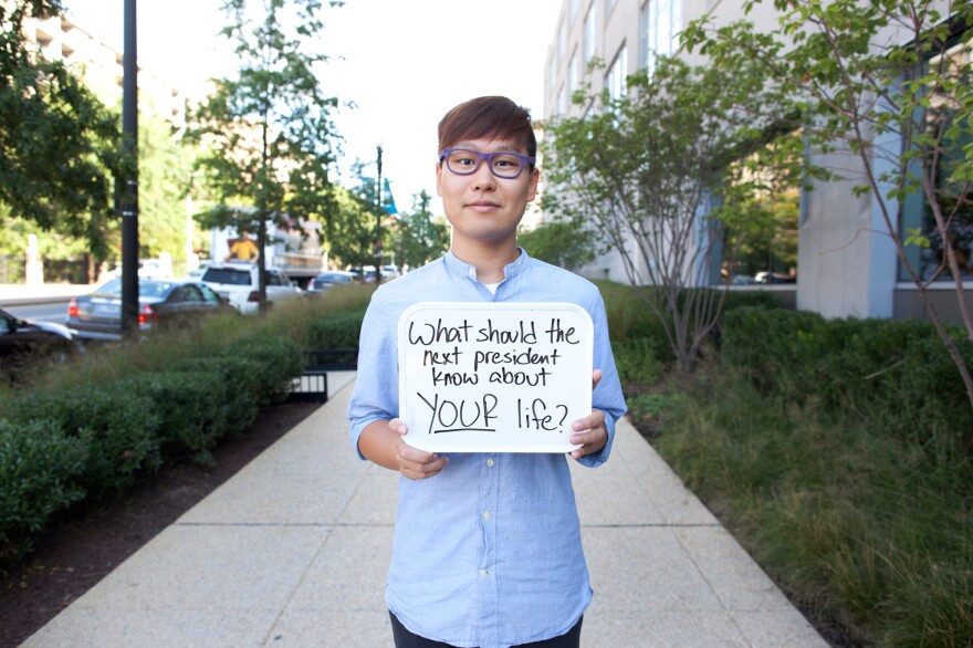 NPR's Wei Quan holds a sign prompting people to respond to the #DearWashington social media conversation about what issues the next president should know about this election season.
