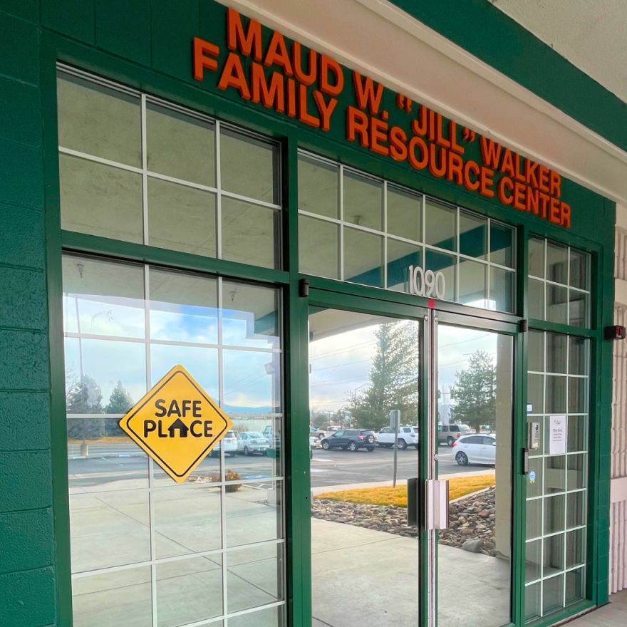 A sign that says “safe place” is attached to a window at the front entrance of a building.