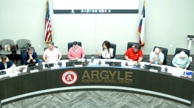 Adults sitting at a long school board meeting table