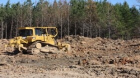 Researchers at Stephen F. Austin State use  heavy equipment to replace soil on an excavated area simulating a commonly used process in mine reclamation known as the pan-scraper technique.