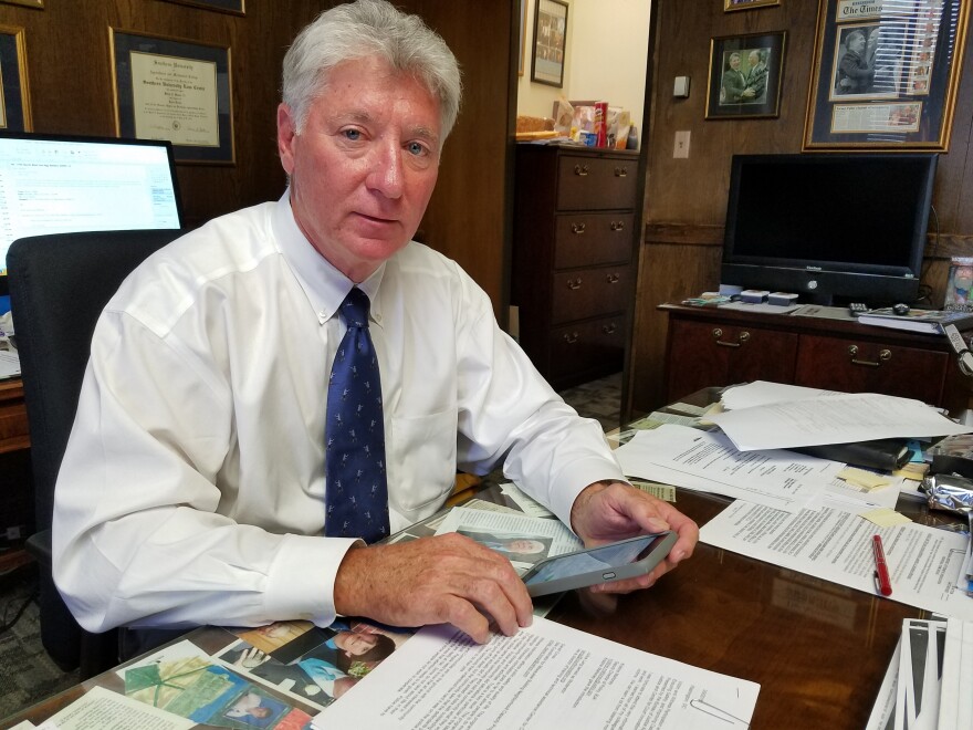 East Baton Rouge District Attorney Hillar Moore, who wants Apple or the FBI to unlock an iPhone 5s, has a stack of articles about encryption on his desk.