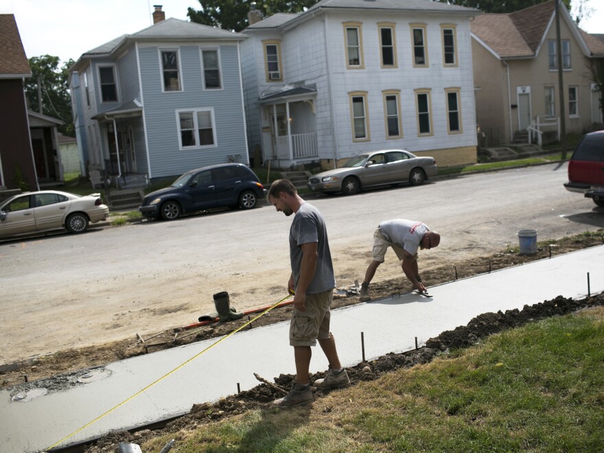 People work on restoring a sidewalk in Springfield. The loss of so many jobs has caused the city's population to drop from more than 80,000 in the 1970s to fewer than 60,000 today.