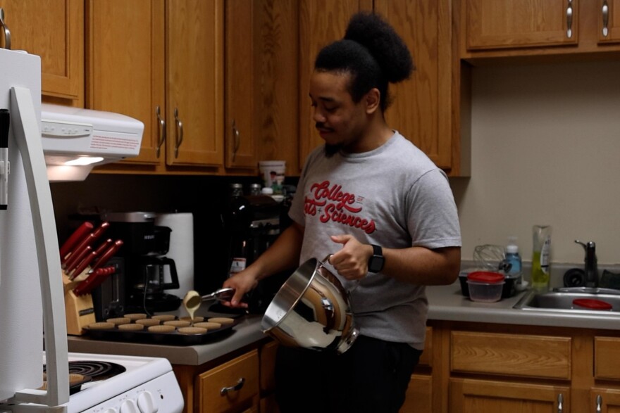 Christian Oates fills the cupcake liners with batter.