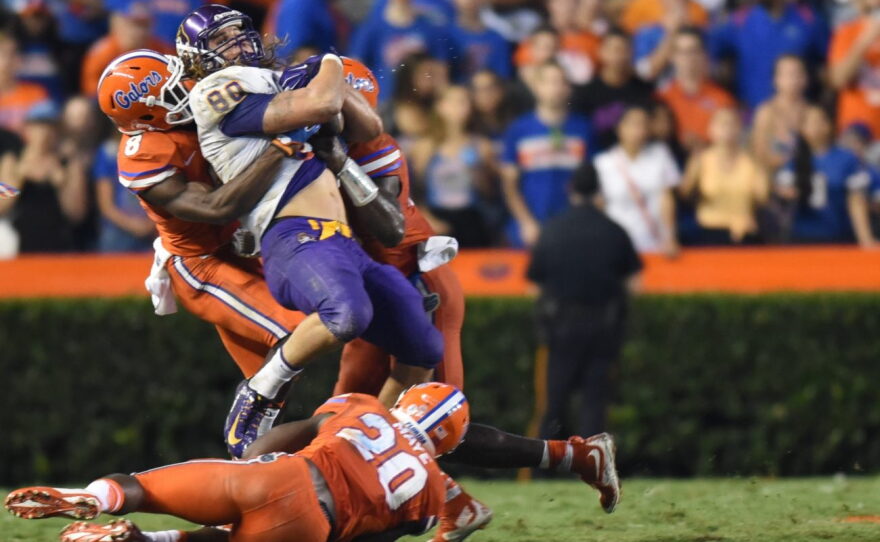East Carolina tight end Bryce Williams (80) is brought down by Florida defensive back Nick Washington (8) and linebacker Jarrad Davis (40).