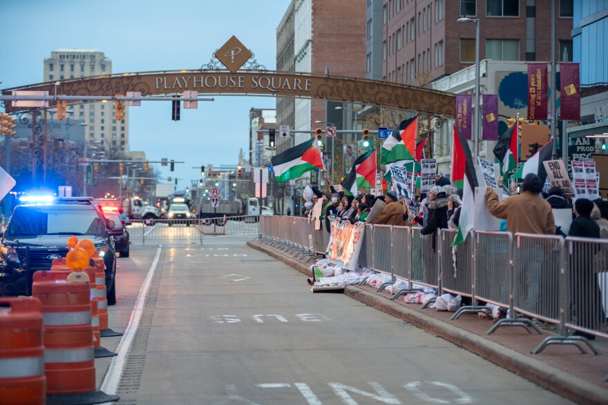 Protesters carrying the flag of Palestine stand behind barricades in Cleveland's Playhouse Square.