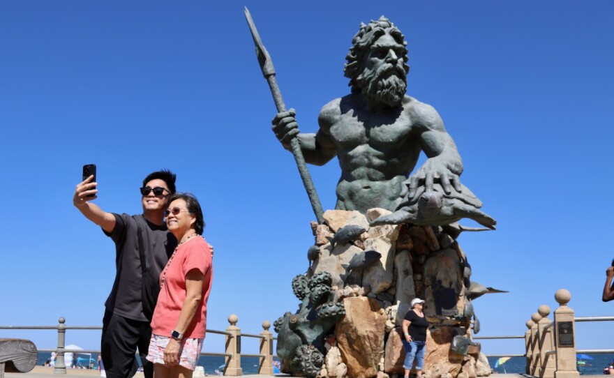 Patrick Vith of Portsmouth takes a picture with his mother, Pim Vith, visiting from the West Coast, with the King Neptune statue behind them on Friday, Aug. 29, 2025.