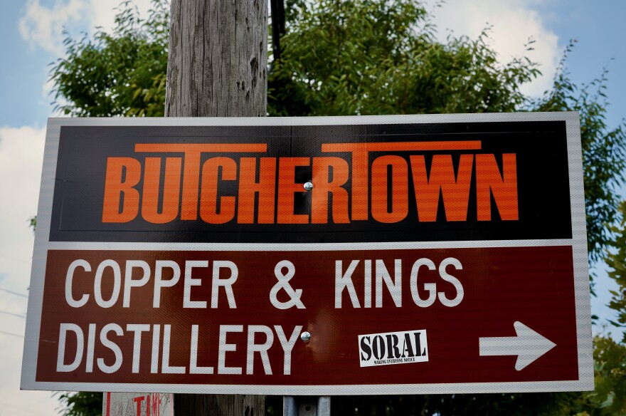 A sign in Butchertown pointing toward Copper & Kings Distillery.