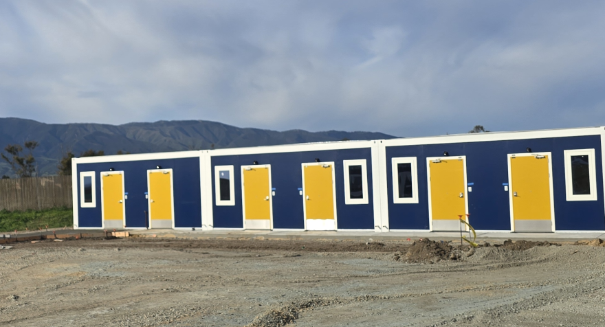 Photo shows a one-story building near Soledad with mountains in the background on a cloudy day.
