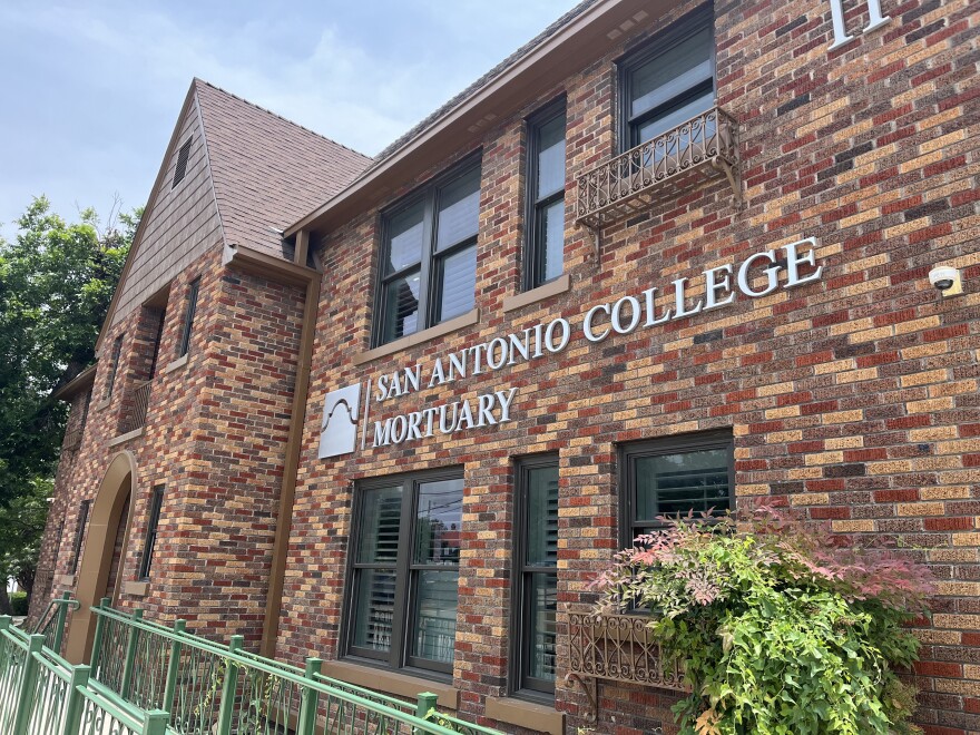 The outside of a brick house with a ramp leading to the front door and the name "San Antonio College Mortuary" attached to the brick.