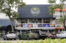 Outside of a sports bar with a balcony and cars parked below 