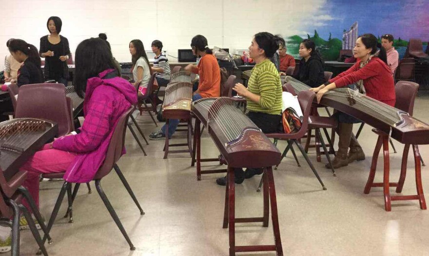 Xiaodan Liang, gu zheng teacher at Hua-Gen Chinese School in Gainesville, teaches her students how to play the gu zheng in class. “For me, teaching students is not about making money but promoting Chinese culture,” she said. (Photo courtesy of Lanqiu Huang)