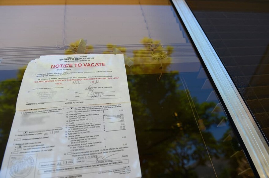 A "Notice to Vacate" is seen in the window of a foreclosed home. (Robyn Beck/AFP/Getty Images)