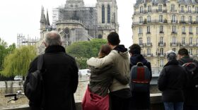 People hug while looking at Notre Dame Cathedral in the aftermath of a fire that devastated the cathedral. Bertrand Guay/AFP/Getty Images