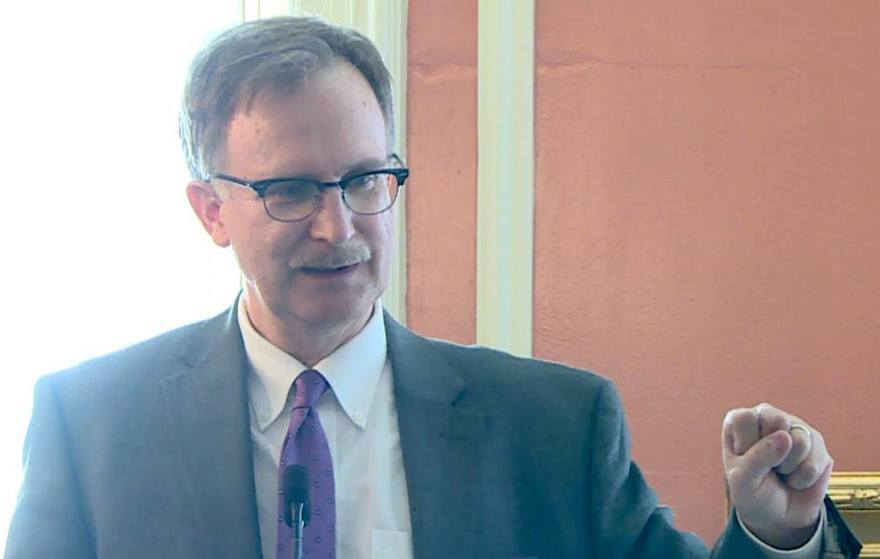 Empire center Health Policy Analyst Bill Hammond, wearing a suit, is speaking