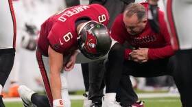A Buccaneers training attends to quarterback Baker Mayfield at the end of the first half of Tampa Bay's loss at Los Angeles on Sunday. Mayfield did not return to the game because of a left shoulder injury.
