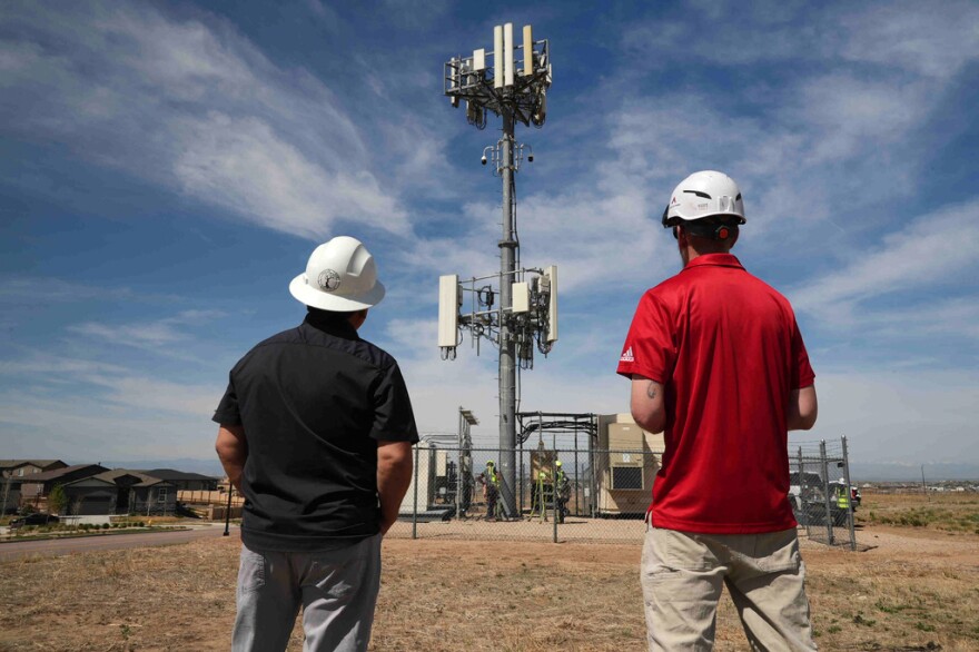 Workers observe a tower where Pano AI cameras are installed for detecting wildfires Monday, April 20, 2026, in Aurora, Colo.