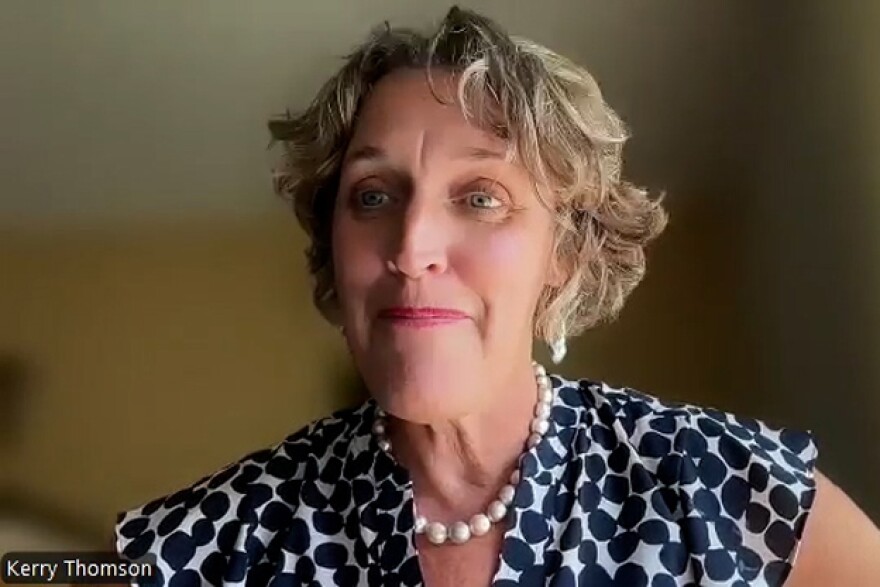 Bloomington Mayor Kerry Thomson on a zoom call. She is smiling and wearing a black and white patterned top with a beaded necklace. 