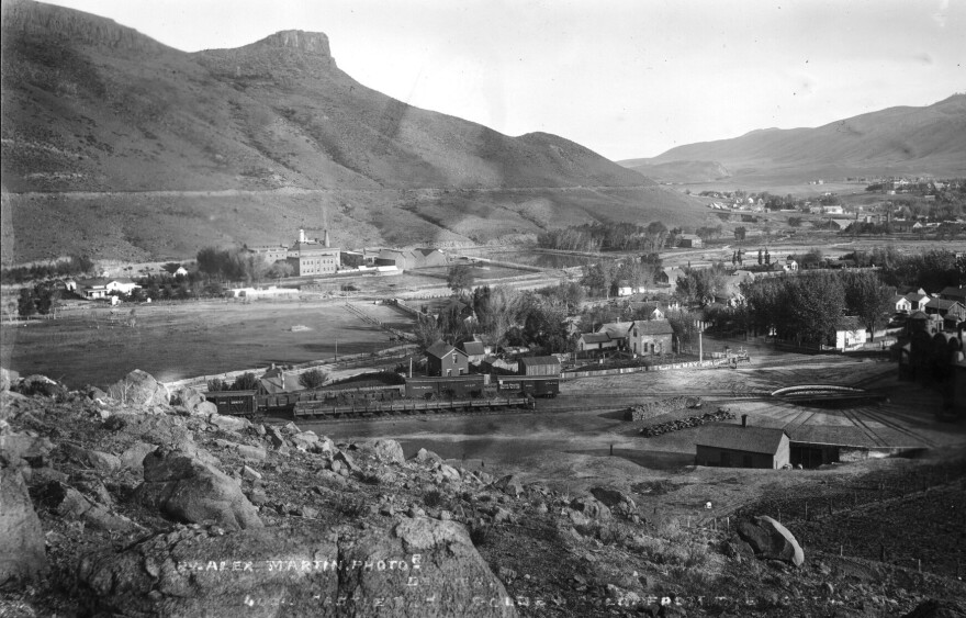 A black and white historic photo of a small town near the foothills.