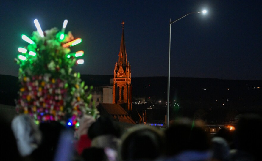 The steeple of St. Nicholas Church, Wilkes-Barre, is seen in the distance as parshioners process to Mass during Friday's commemoration of Our Lady of Guadalupe's feast day.