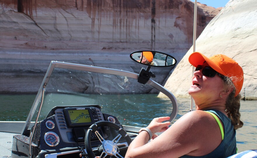 Sheri Facinelli steers a speedboat into a side canyon at Lake Powell. The reservoir is approaching its lowest level since it was built in the 1960s.