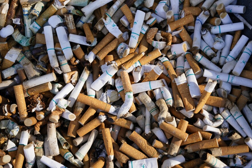 Cigarette butts and residue fill a smoking receptacle outside a federal building on Capitol Hill in Washington, Thursday, April 15, 2021.