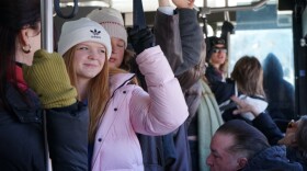 People wearing hats ride a bus.