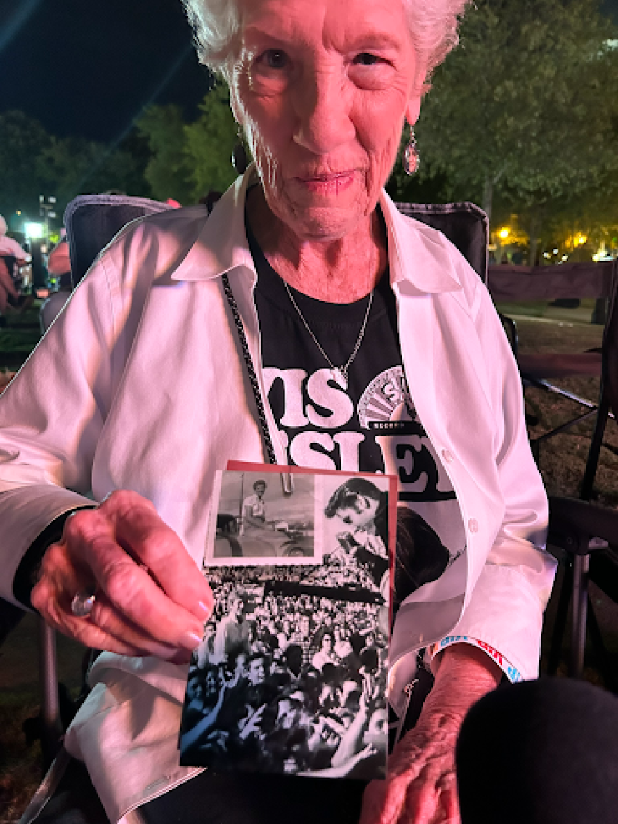 Brenda Hildenbrand holds up a photo from Elvis Presley’s 1956 performance, where she can be seen in a white blouse standing up in the crowd (left of frame), in Tupelo, Mississippi, on Saturday, Sept. 26, 2026.