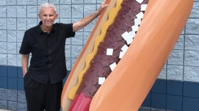 Pal Barger poses with giant chili dog sculpture.
